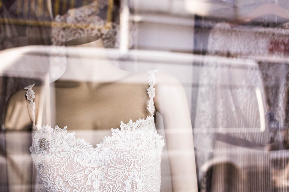 A photo of a shop window with many types of wedding dresses inside