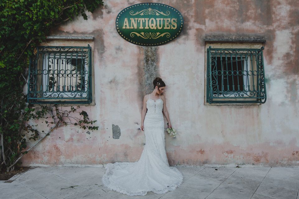 A photo of a woman in a mermaid wedding dress on the backdrop of an old villa